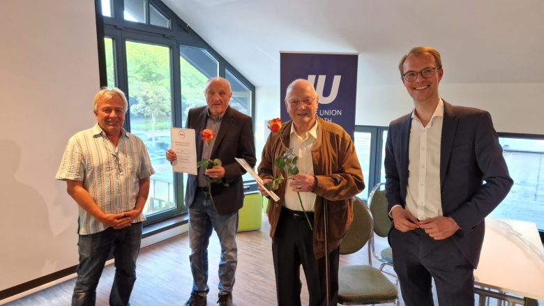 Dr. Christian Untrieser (rechts) mit der Jubiläums-Mitgliedern der CDU Erkrath. Sie halten eine Rose und eine Urkunde in der Hand.