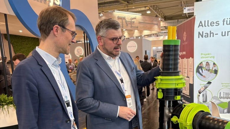 Die NRW-Landtagsabgeordneten Dr. Christian Untrieser (links im Bild) und Peter Blumenrath (rechts im Bild) schauen sich eine technische Apparatur auf der Messe e-world genauer an.