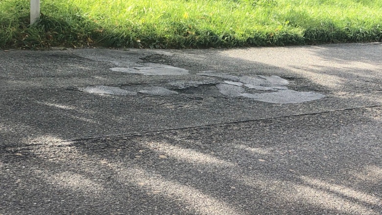 Die asphaltierte Straße L357 in Haan-Gruiten mit einigen Schlaglöchern und Flicken