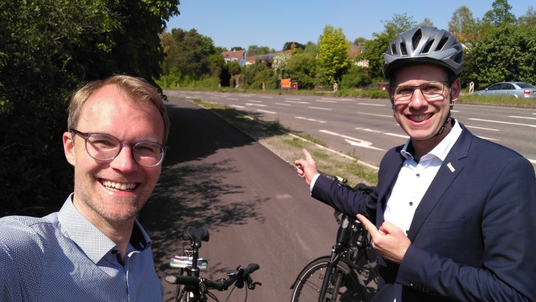 Dr. Christian Untrieser (links) und Christoph Schultz (rechts) mit Fahrradhelm und Rädern auf der sanierten Bergischen Allee in Hochdahl.