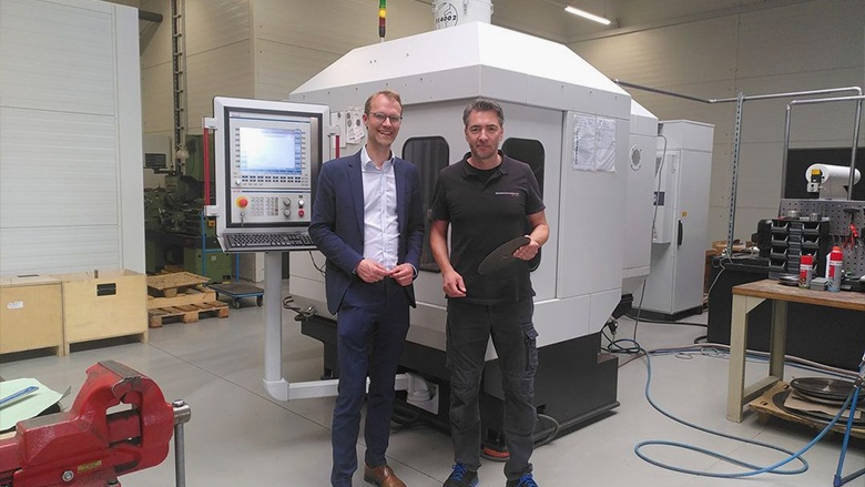 Starke heimische Wirtschaft - Besuch bei Staubes Schneidtechnik in Haan Dr. Christian Untrieser und ein Mitarbeiter von Staubes Schneidetechnik (Haan) stehen vor einer Maschine.