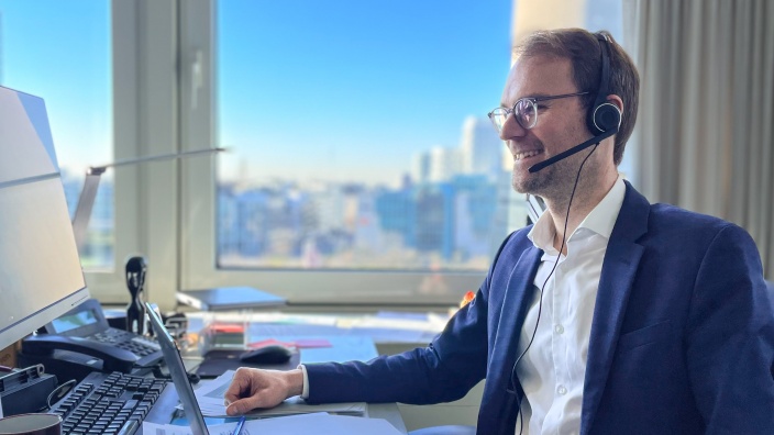 Christian Untrieser sitzt mit Headset vor dem PC in seinem Landtagsbüro. Er trägt ein weißes Hemd, blaues Jackett und eine rundliche, graue Brille.