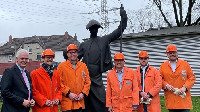 Landtagsabgeordnete zu Besuch bei HKM. Sie tragen Schutzjacken und -helme in leuchtendem Orange.